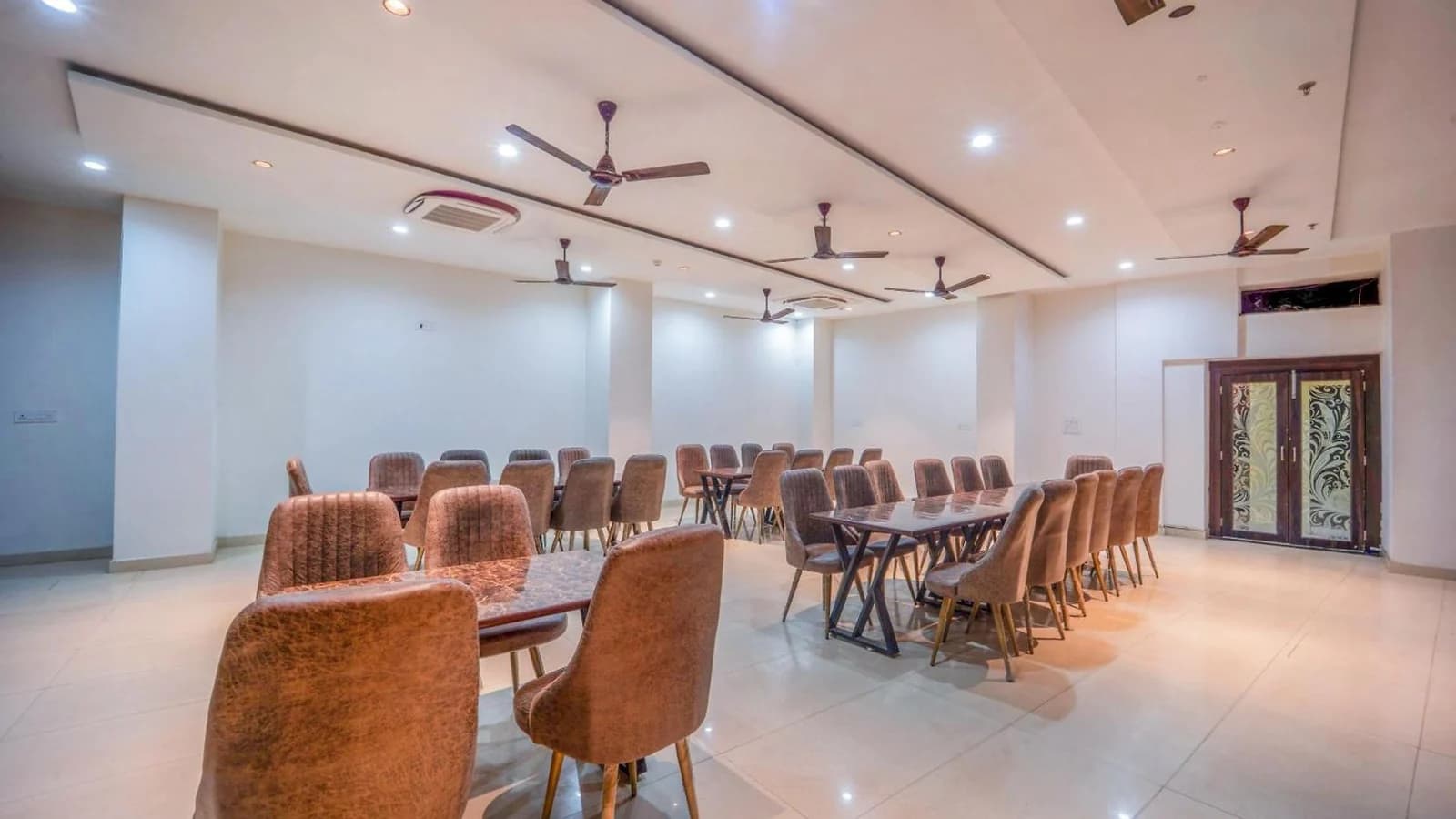 Tables and upholstered dining chairs in Hotel Augusto's restaurant