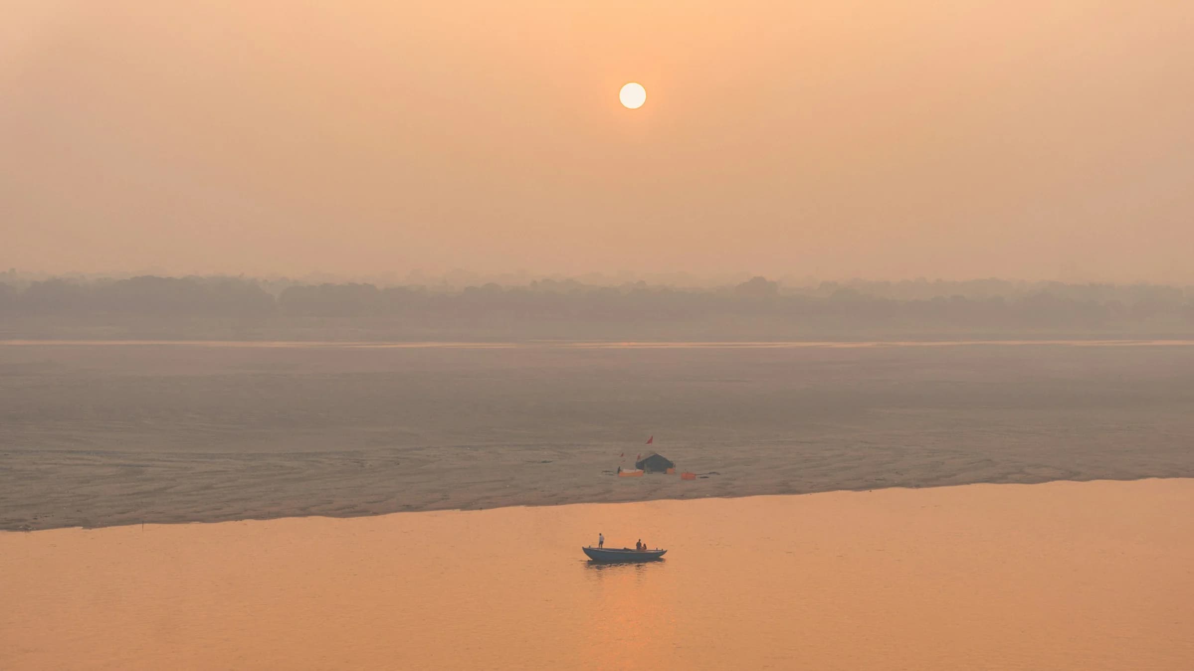 Small boats on the Ganga in the warm light of sunrise