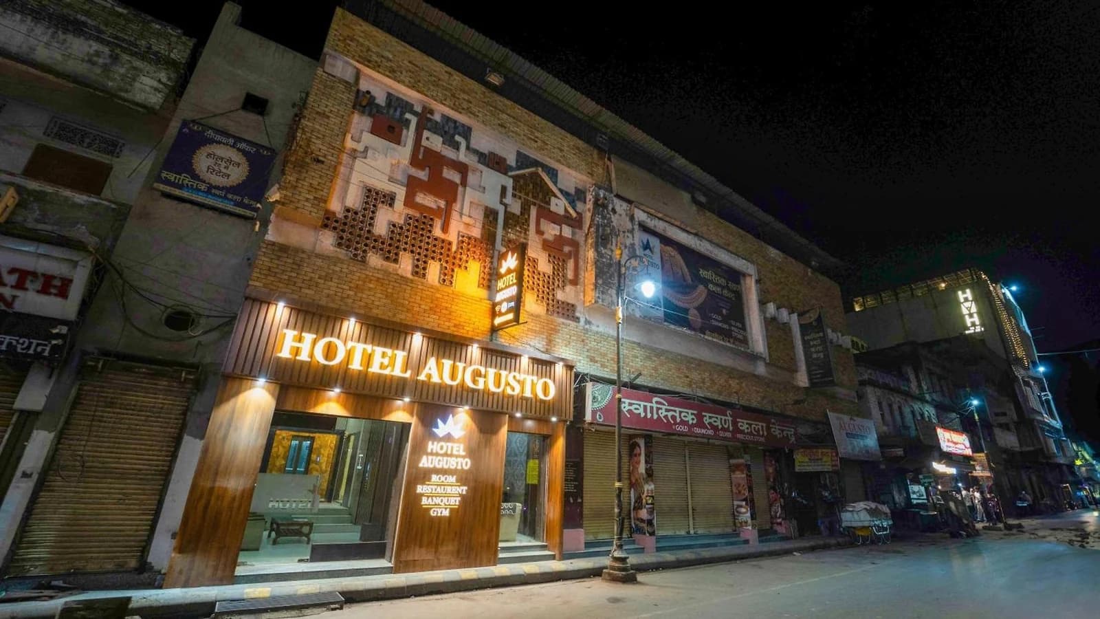 Hotel Augusto's exterior and illuminated sign after dark