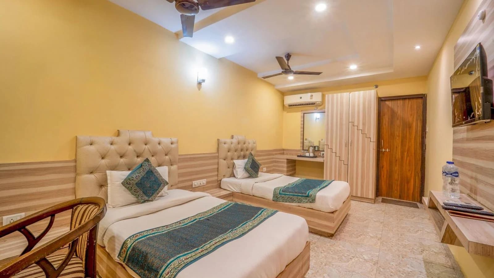 Two single beds with green runners in a guest room at Hotel Augusto